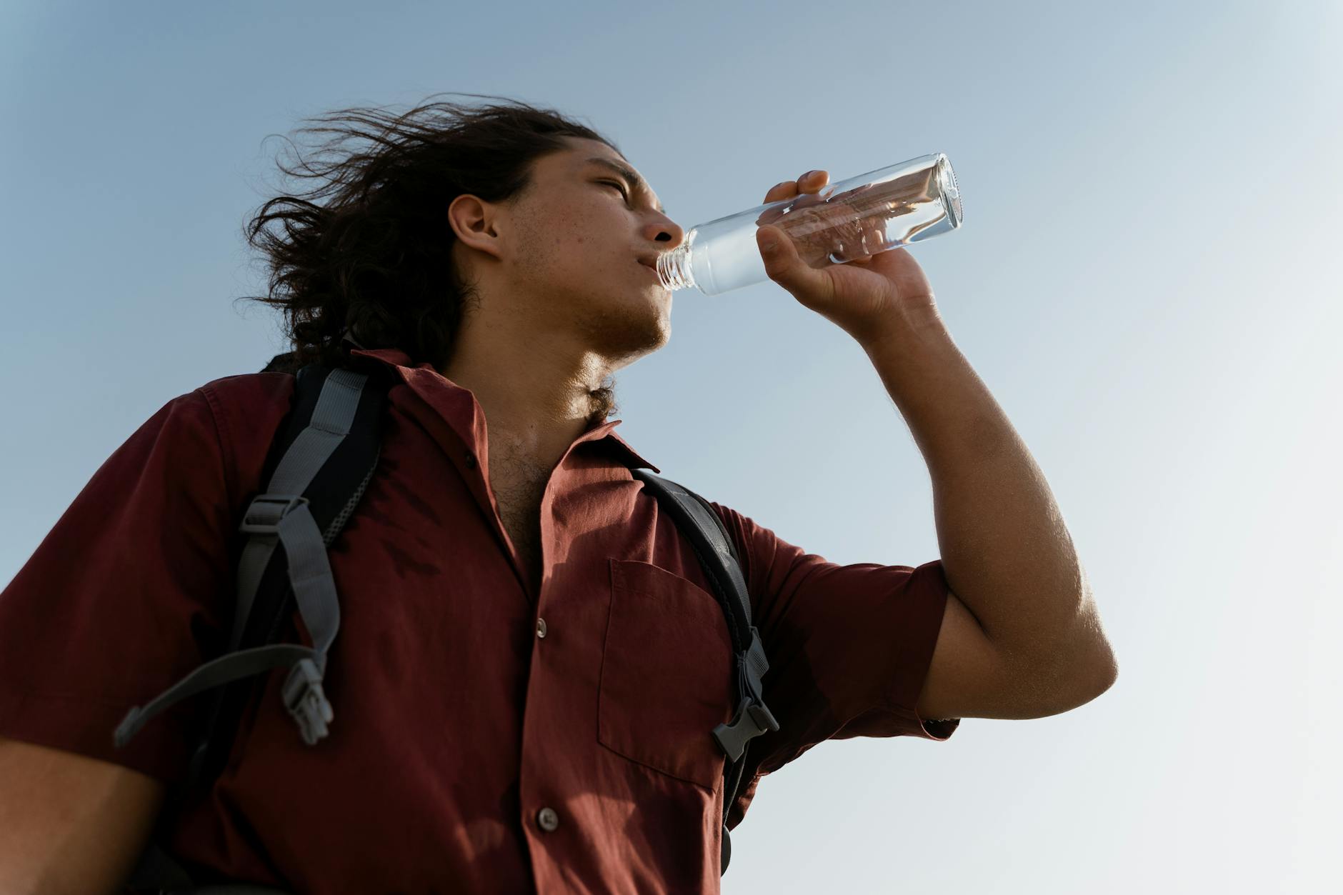 a man drinking purified bottled water on a hike